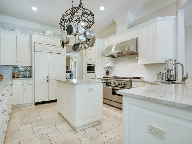 a kitchen with stainless steel appliances granite countertop a sink a stove a refrigerator and cabinets