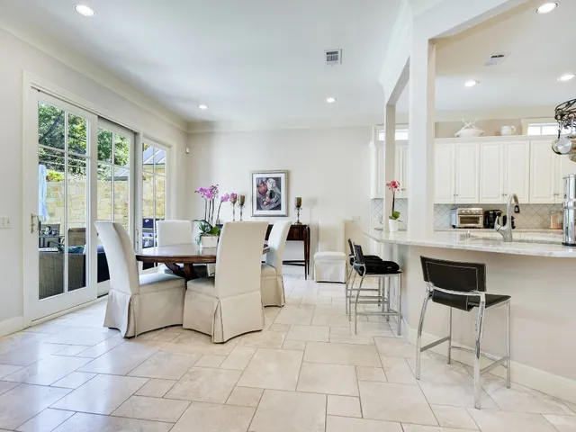 a living room with couches and kitchen view with wooden floor