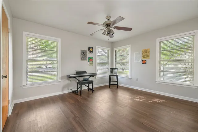 a view of a livingroom with furniture a ceiling fan and wooden floor