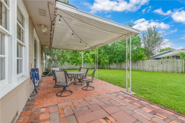 a view of a patio with table and chairs under an umbrella