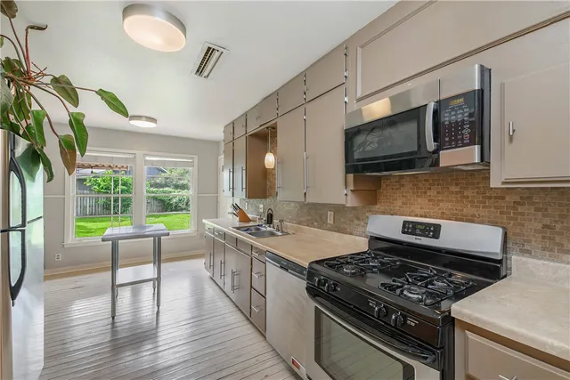 a kitchen with a stove a sink and a microwave
