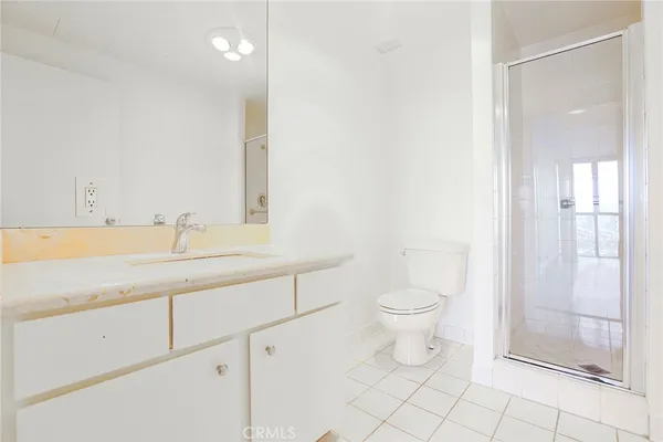 a bathroom with a granite countertop sink a toilet and a shower