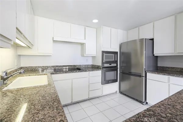 a kitchen with a refrigerator sink and cabinets
