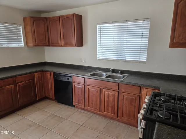 a kitchen with granite countertop a stove and a sink