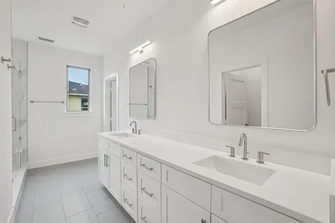 a spacious bathroom with double sink and a mirror