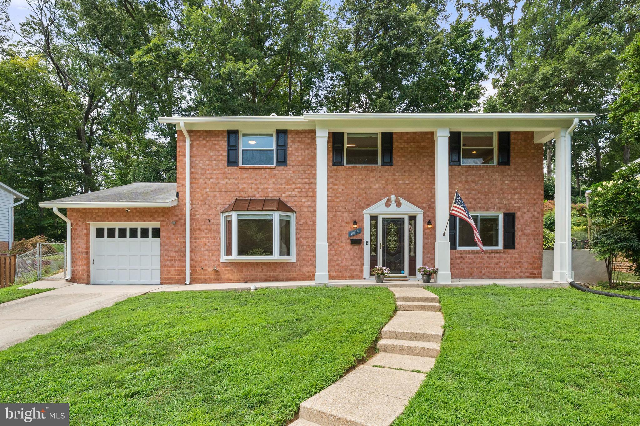 a front view of a house with a yard and garden