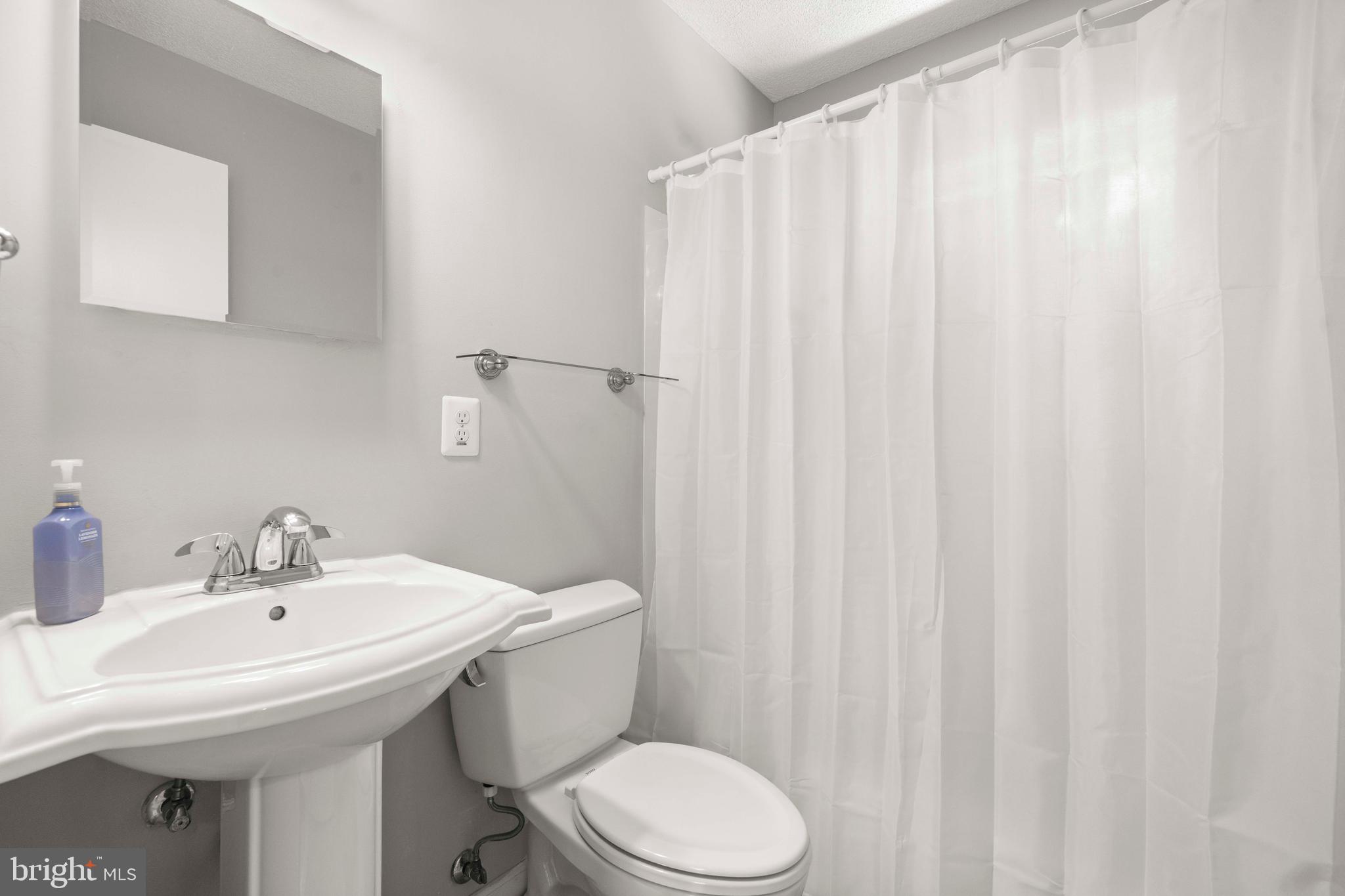 8414 Thames Street Springfield, VA 22151 - Photo 29 of 45 a bathroom with a sink a toilet and a mirror