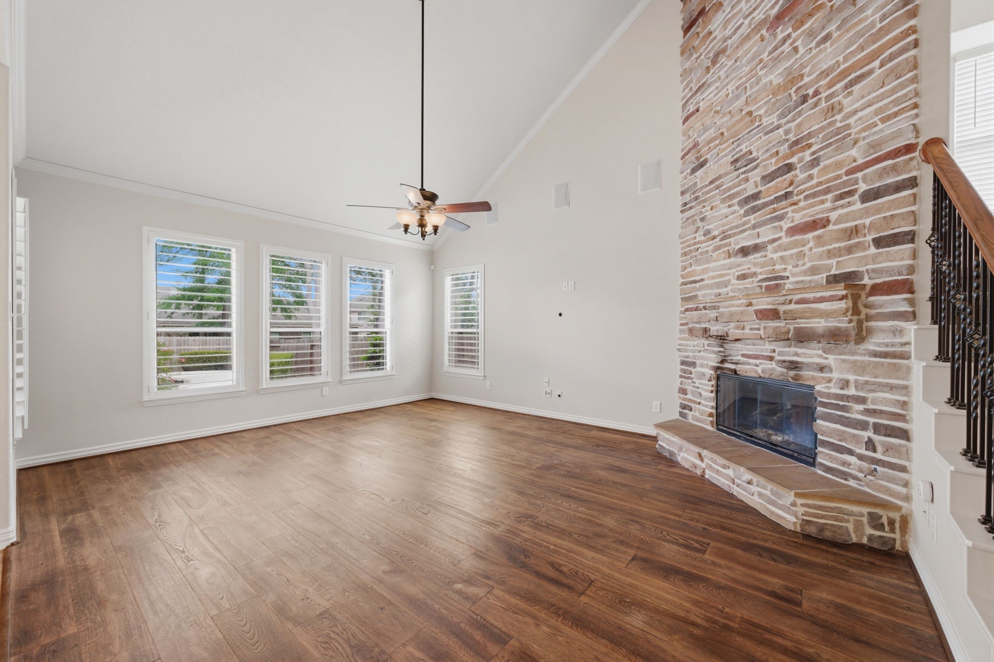 315 Arbor Ridge Lane Conroe, TX 77384 - Photo 14 of 48 an empty room with wooden floor fireplace and windows
