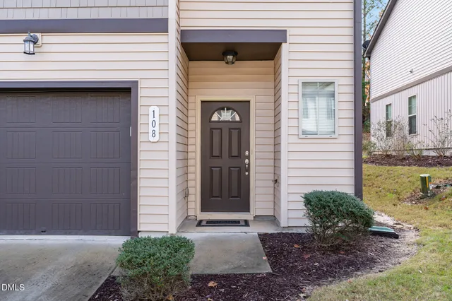 a view of a white house with large windows and a small yard