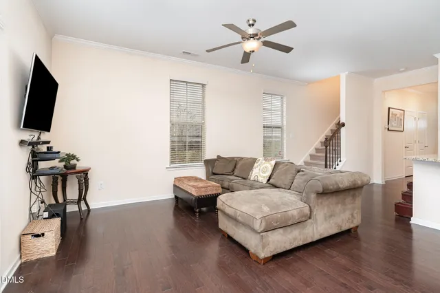a view of a white house with a small yard and large tree