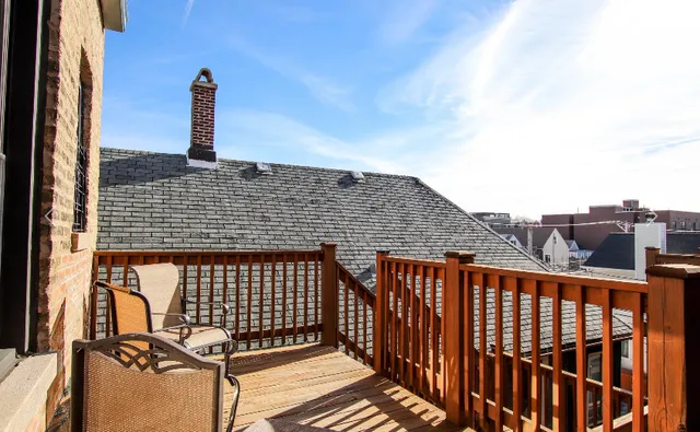 a view of roof deck with wooden fence and wooden floor