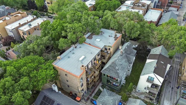 an aerial view of a house with a big yard and large tree