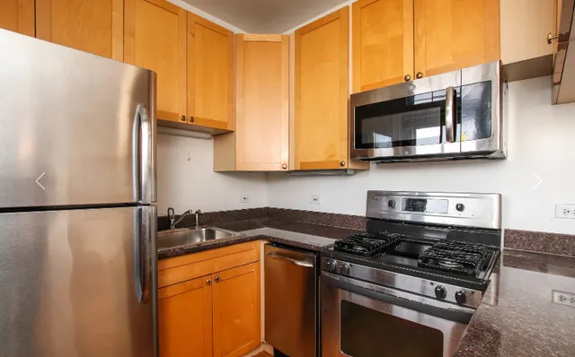a kitchen with stainless steel appliances granite countertop a refrigerator stove top oven and sink