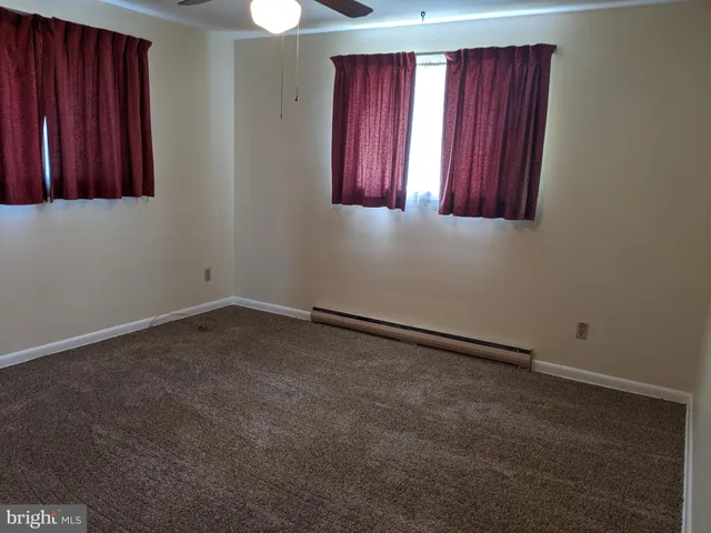 an empty room with windows and closet
