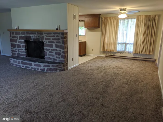 a view of an empty room with a fireplace and a window