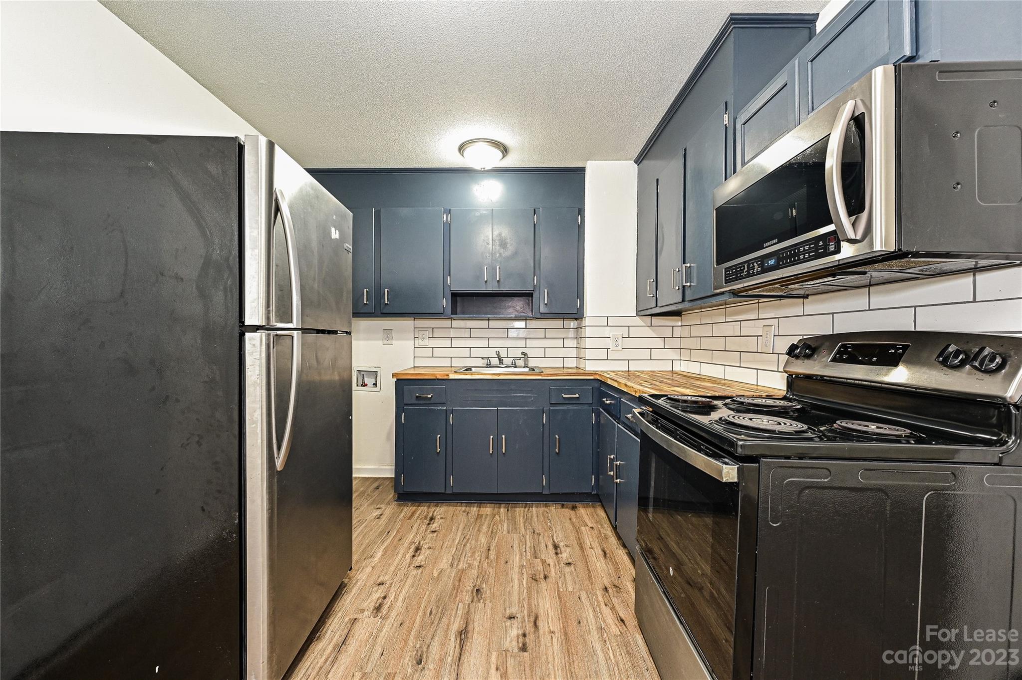 512 West Robinson Street Dallas, NC 28034 - Photo 16 of 17 a kitchen with stainless steel appliances a stove a sink a microwave a refrigerator and cabinets