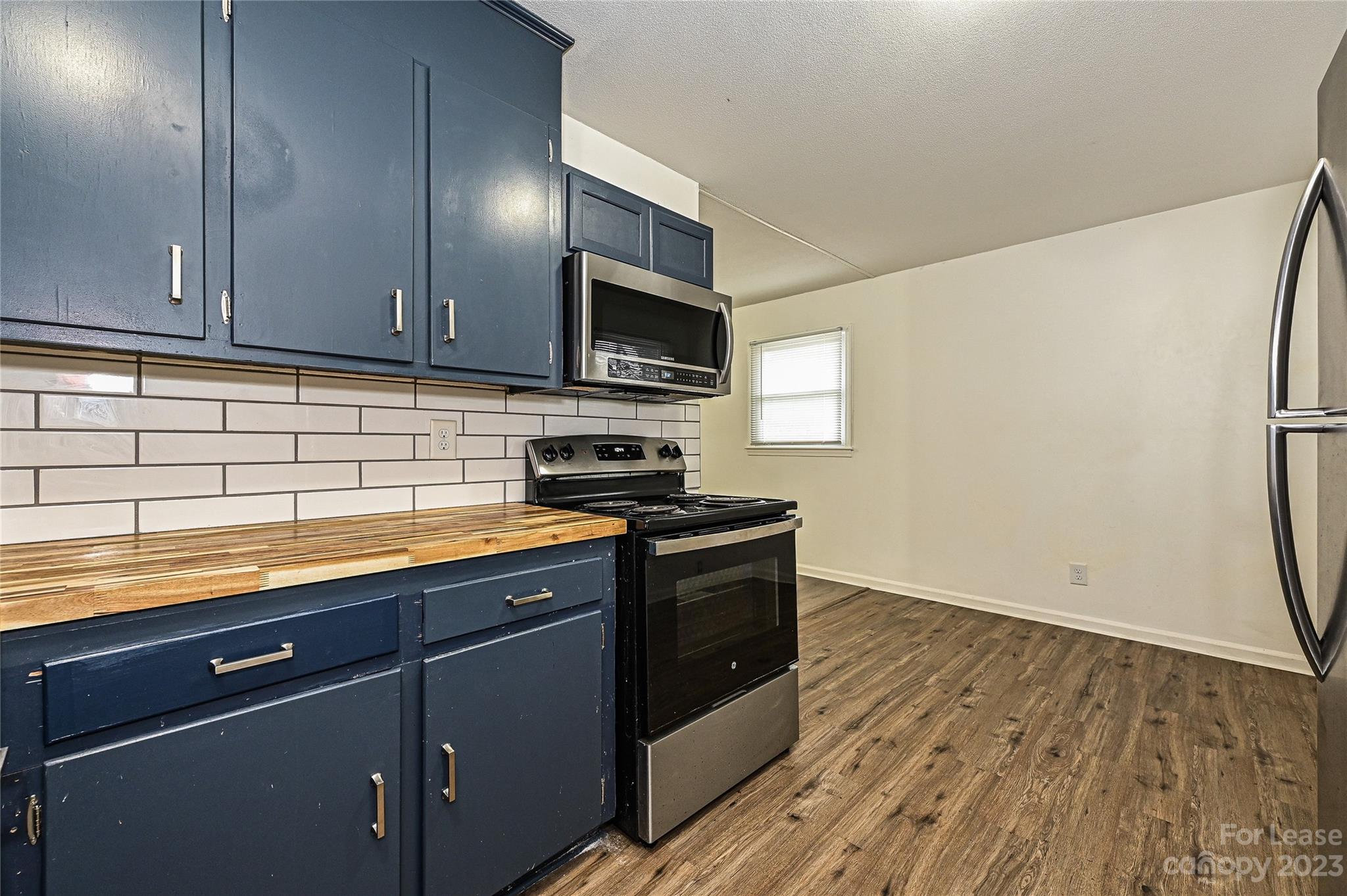 512 West Robinson Street Dallas, NC 28034 - Photo 2 of 17 a kitchen with stainless steel appliances granite countertop a stove a sink and a refrigerator