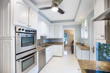 113 South Gordon Road Fort Lauderdale, FL 33301 - Photo 24 of 53 a kitchen with stainless steel appliances granite countertop a stove sink and cabinets