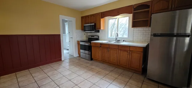 a kitchen with stainless steel appliances granite countertop a refrigerator and a sink