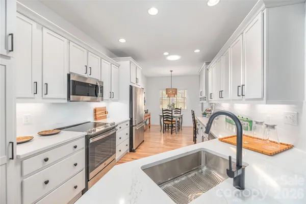 a kitchen with stainless steel appliances granite countertop a sink and a stove top oven