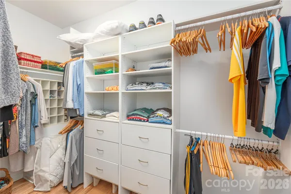 a view of walk in closet with clothes and shoes