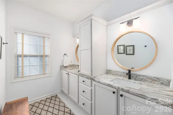 a bathroom with a granite countertop sink mirror and vanity