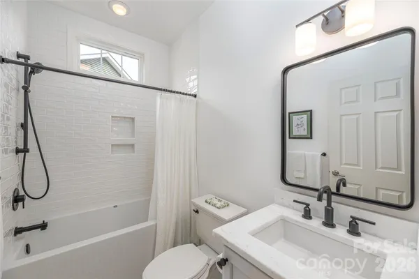 a bathroom with a granite countertop sink a toilet and shower