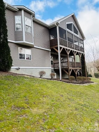 a view of a house with a yard and wooden fence