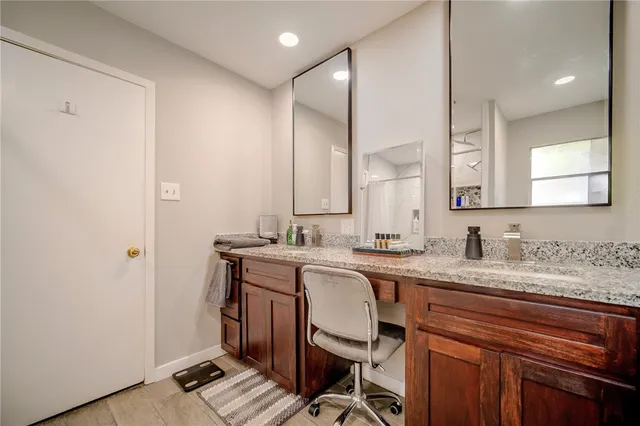 a spacious bathroom with a granite countertop sink a mirror and a