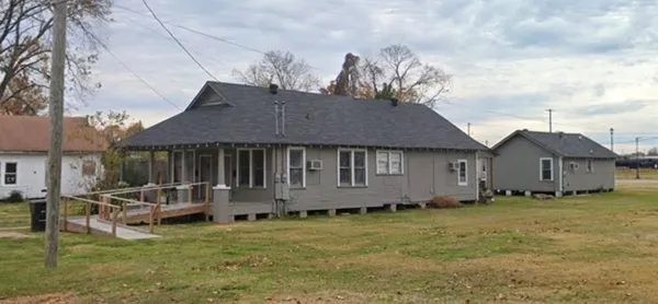 a view of a house with a yard and sitting area