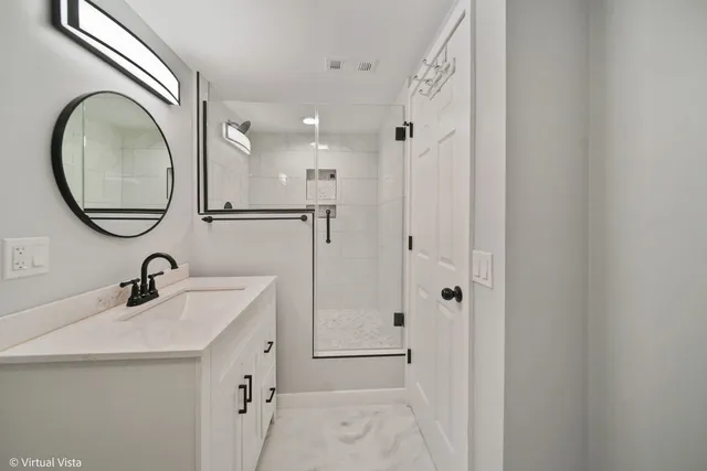 a bathroom with a double vanity sink mirror and shower