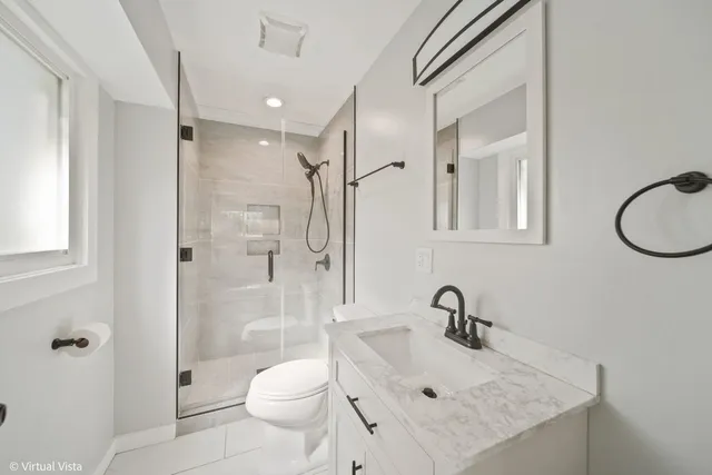 a bathroom with a sink a toilet and shower