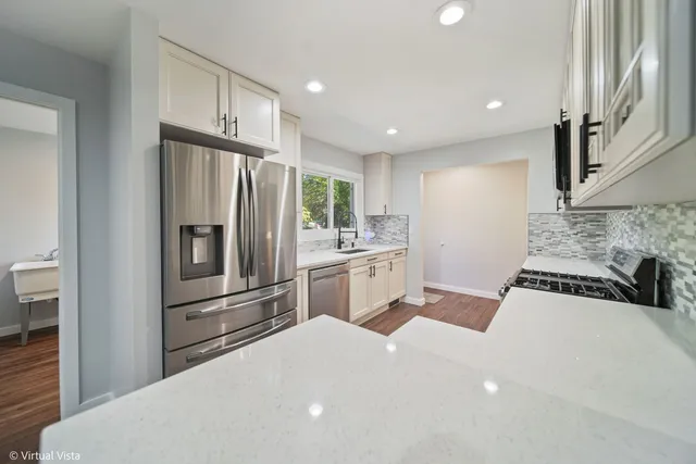 a kitchen with white cabinets and stainless steel appliances