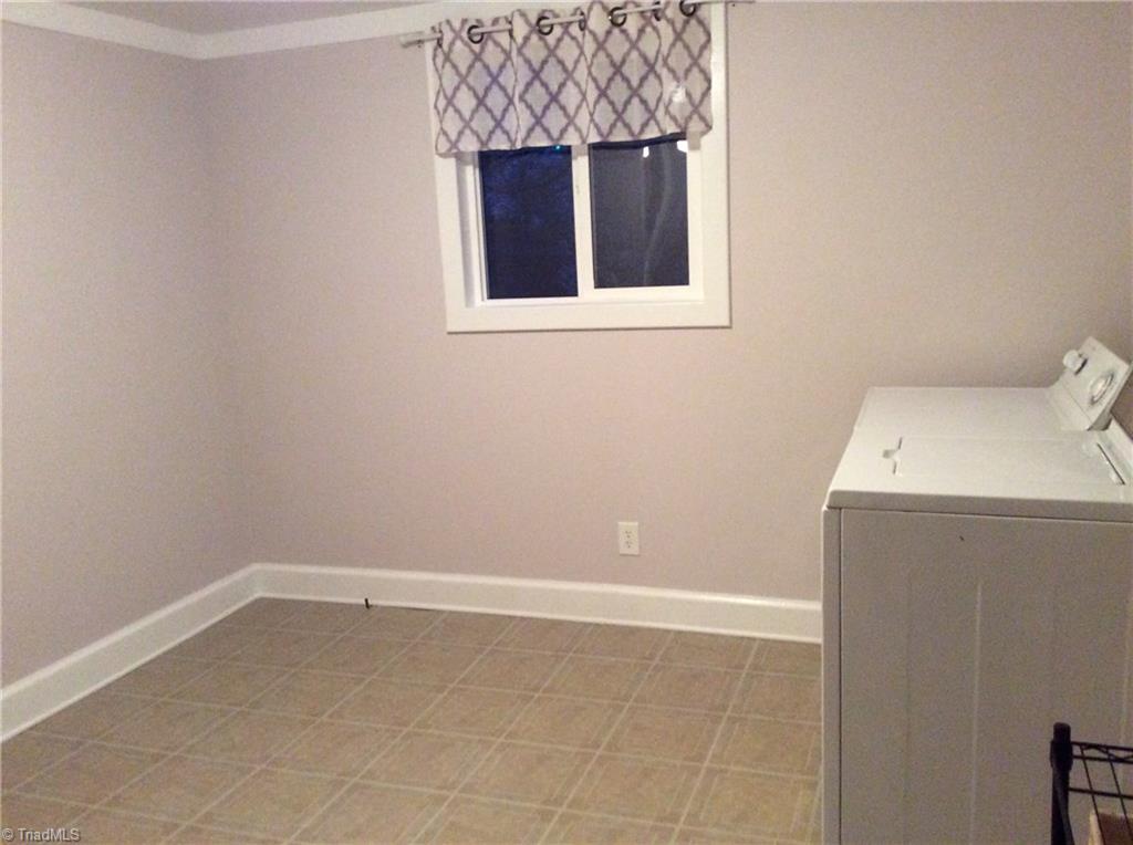 521 Cemetery Street Ronda, NC 28670 - Photo 12 of 13 Bedroom that the current owner used as laundry however you can use as bedroom if needed. Washer & Dryer will stay for the new owners use. Note: hardwood floors under vinyl.
