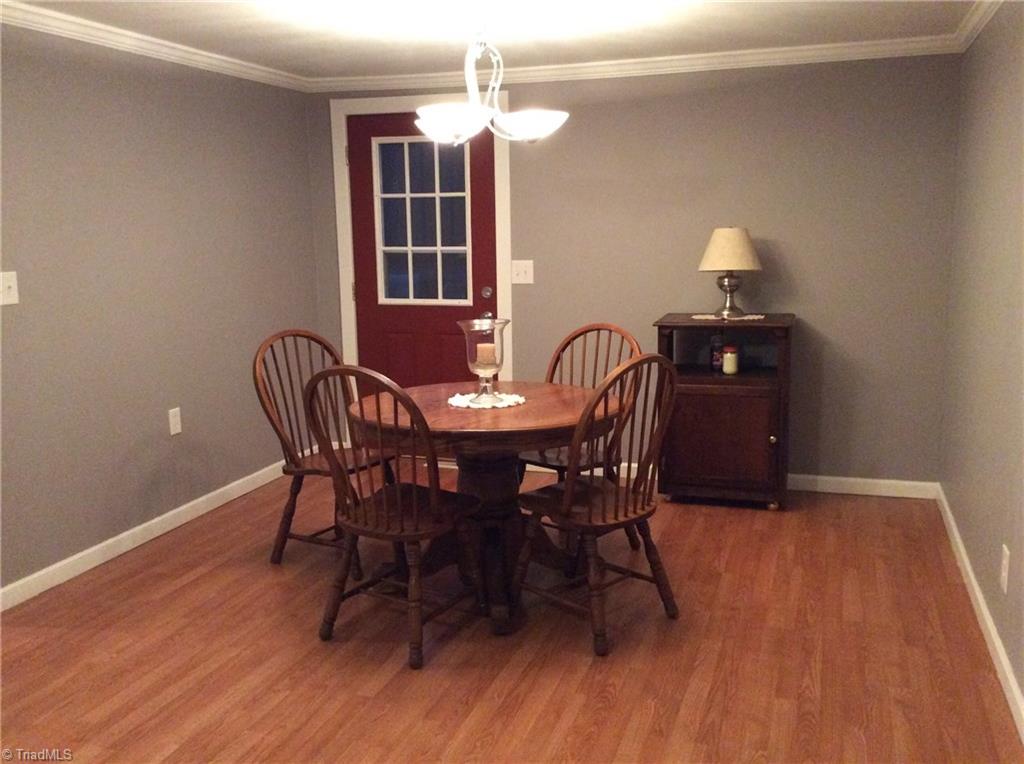 521 Cemetery Street Ronda, NC 28670 - Photo 5 of 13 Dining room with laminate flooring, updated lighting, walkout door to rear deck.