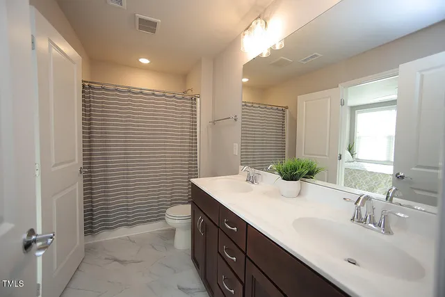 a bathroom with a sink double vanity and a toilet