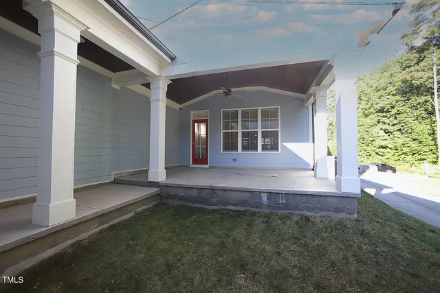 a view of a house with backyard and porch