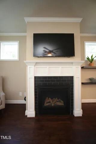 a living room with a fireplace a flat screen tv and a fireplace