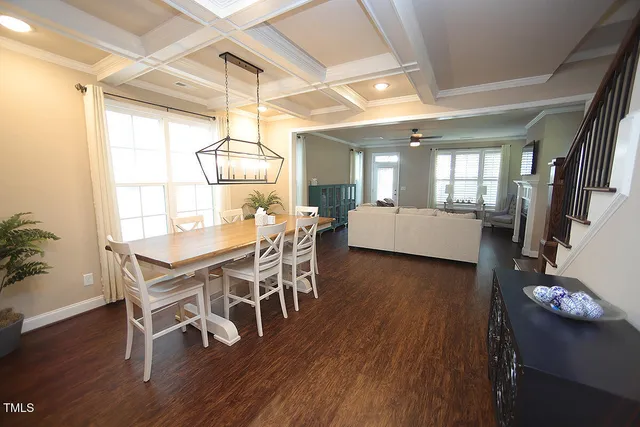 a dining room with wooden floor furniture and a chandelier