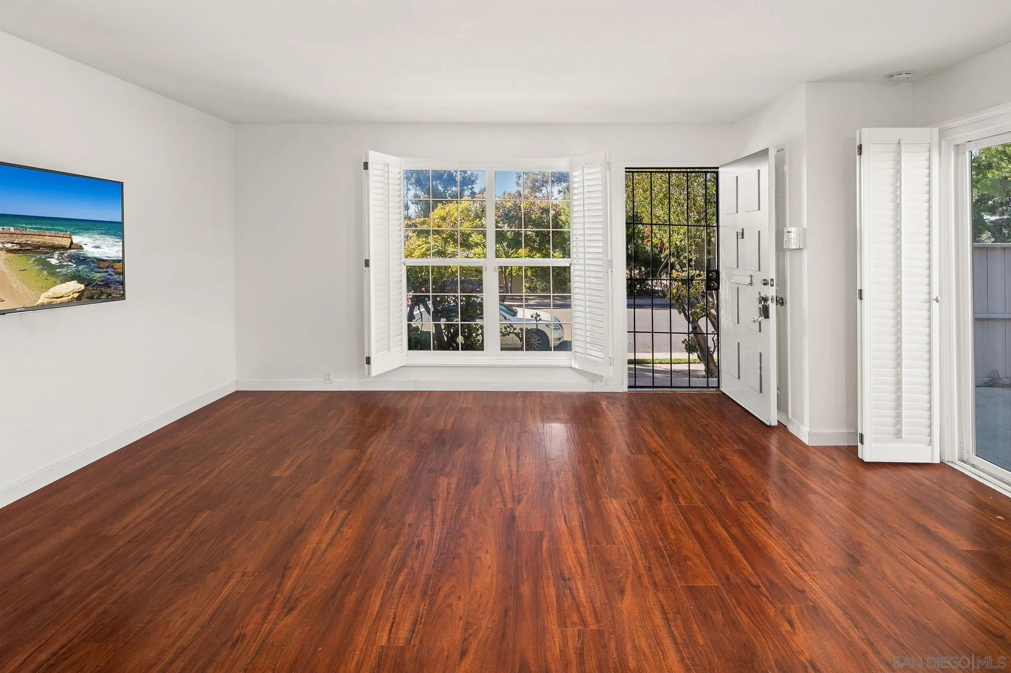 9679 Easter Way San Diego, CA 92121 - Photo 12 of 28 a view of an empty room with wooden floor and a window