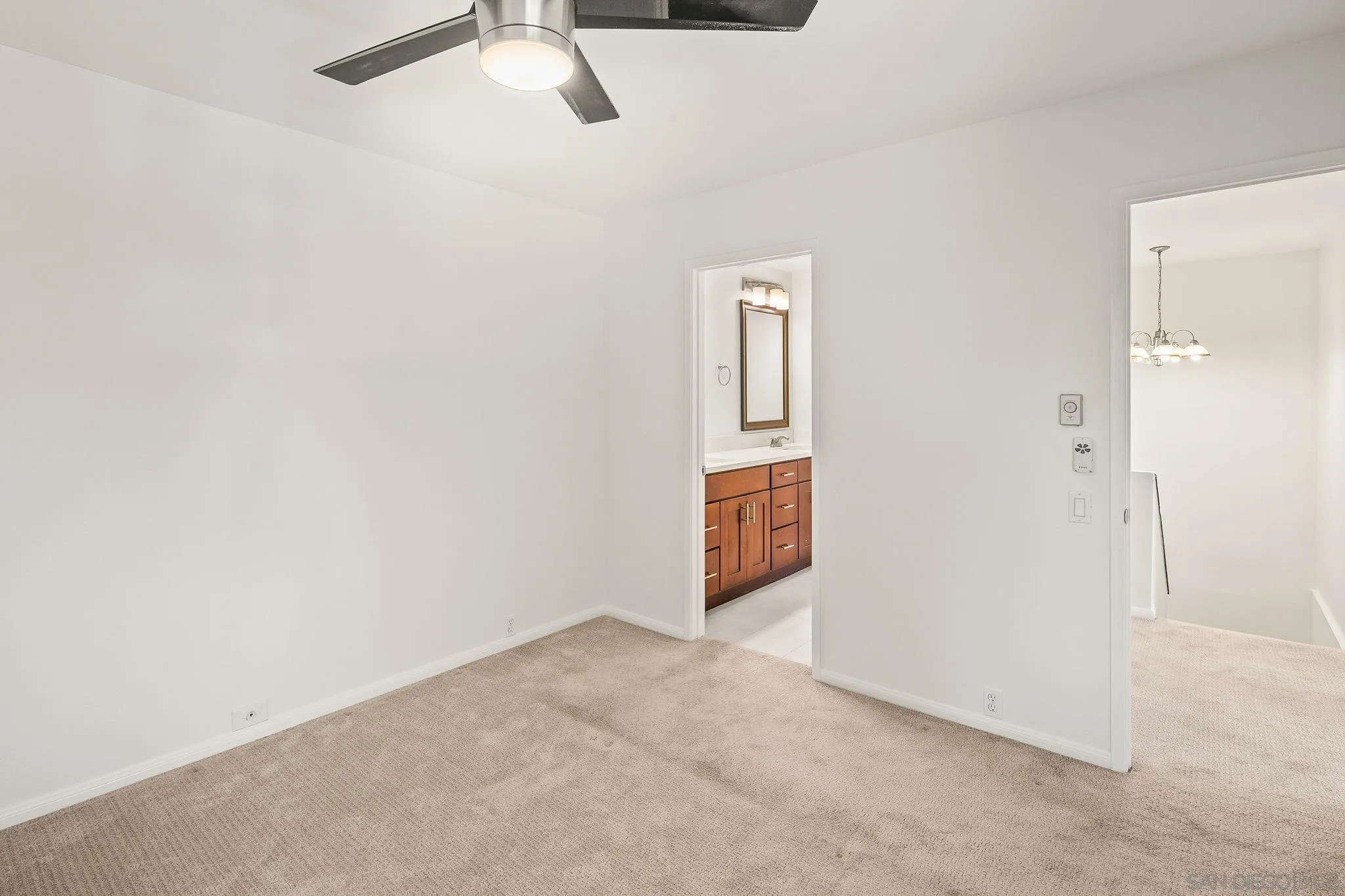 9679 Easter Way San Diego, CA 92121 - Photo 26 of 28 an empty room with a ceiling fan and carpet
