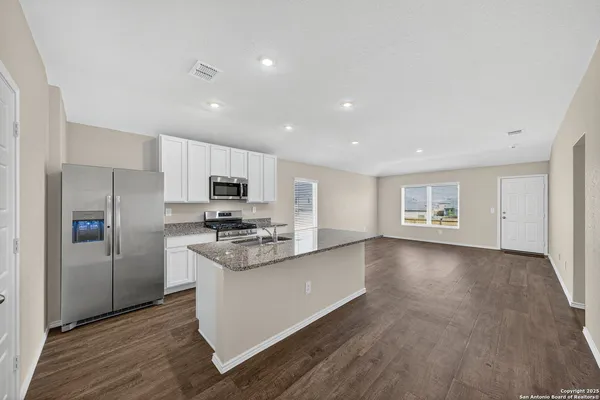 a kitchen with stainless steel appliances a refrigerator and a stove top oven