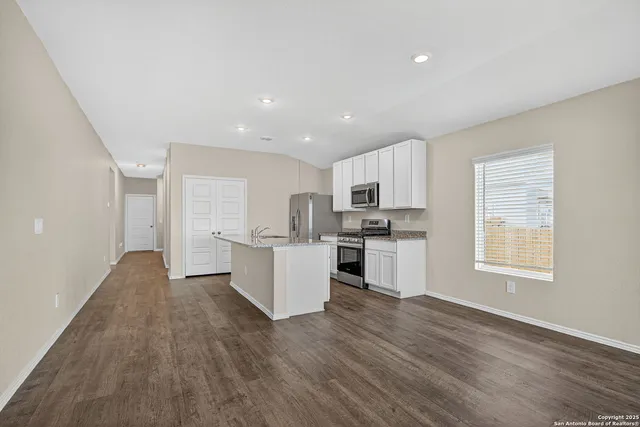 a view of kitchen with wooden floor and electronic appliances