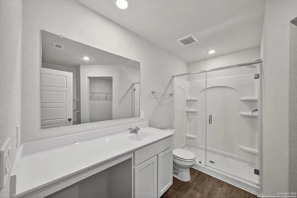 a bathroom with a double vanity sink toilet mirror and shower