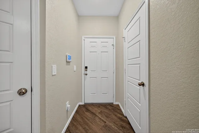 a view of a hallway with closet and wooden floor