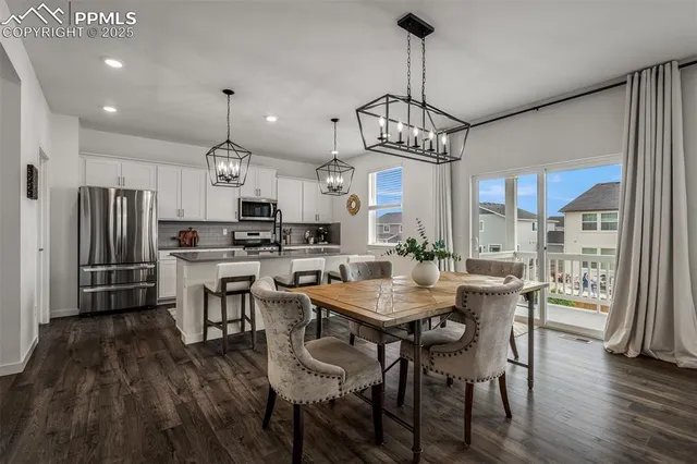 a view of a dining room and livingroom with furniture wooden floor a chandelier
