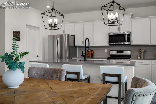 a living room with furniture a chandelier and a flat screen tv