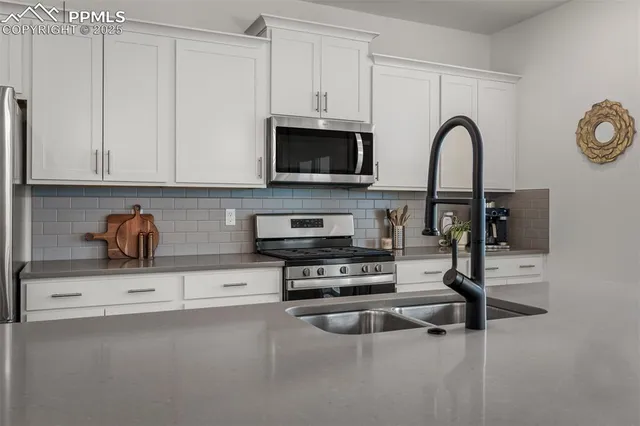 a kitchen with stainless steel appliances granite countertop a stove a microwave and cabinets