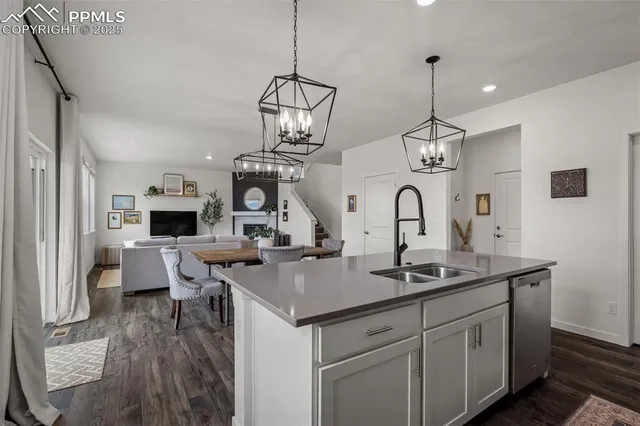 a view of living room with granite countertop furniture a fireplace and chandelier