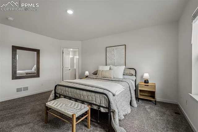 a bedroom with a bed table and chair